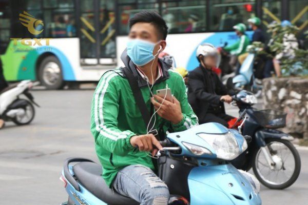 Xe tải đeo tai nghe khi lái, kết hợp với hình ảnh sản phẩm hộp số xe tải trên đường. An toàn và quy định pháp luật khi tham gia giao thông.